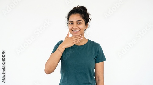 Young Indian woman with hand on chin smiling confidently against a white background