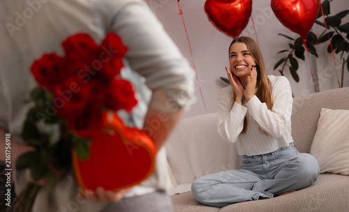 фотографія Excited woman receiving roses and heart-shaped gift from partner