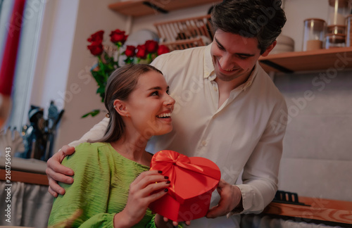 Foto Happy couple sharing heart-shaped gift and affectionate look