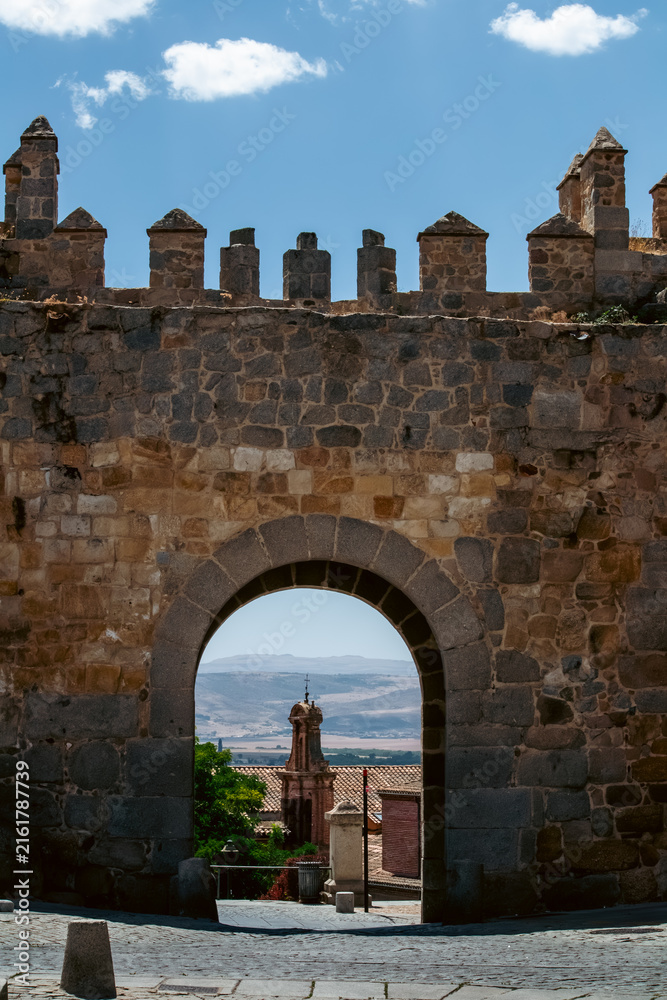 Obraz premium Medieval City Gate Arch Framed View of Landscape and Tower in Avila Spain