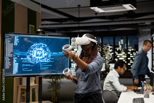 Konstfotografi Programmer in a tech startup office uses a VR headset and artificial intelligence to automate repetitive tasks and speed up feature implementation