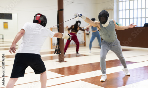 фотографія Group of men and women in protective headgear rehearse attack and defense techni