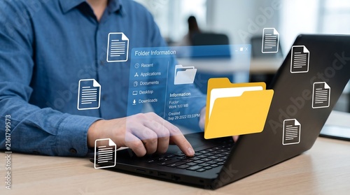 Man organizing digital files and folders on a laptop computer with virtual document icons