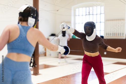 Fotografía Women in protective equipment conduct a training fencing match