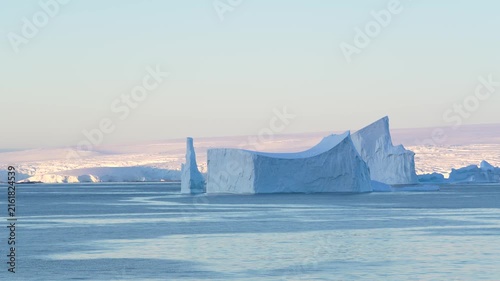 Huge Tabular Iceberg in Antarctica at Sunset. Beautiful Snow Covered Mountains Epic Nature Remote Destination. Incredible Panoramic Vista
