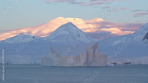 Antarctica Stunning Huge Tabular Iceberg at Sunset with Snow Covered Mountains Epic Remote Nature Destination. Incredible Massive Ice Floating