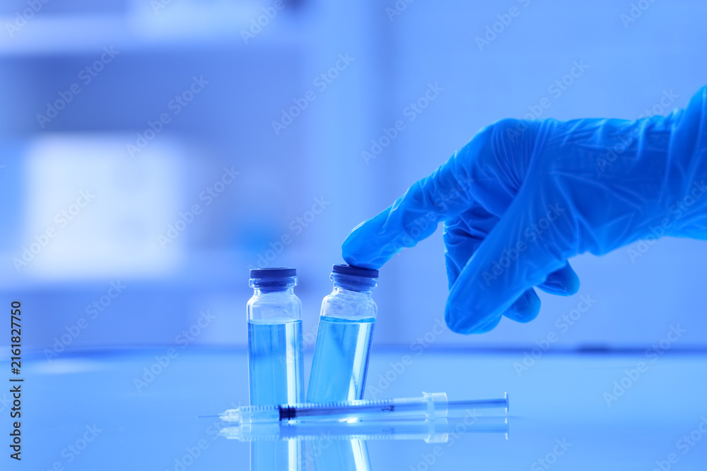 Fototapeta premium Vaccine development and medical research, gloved hand with vials and syringe for drug discovery and healthcare innovation