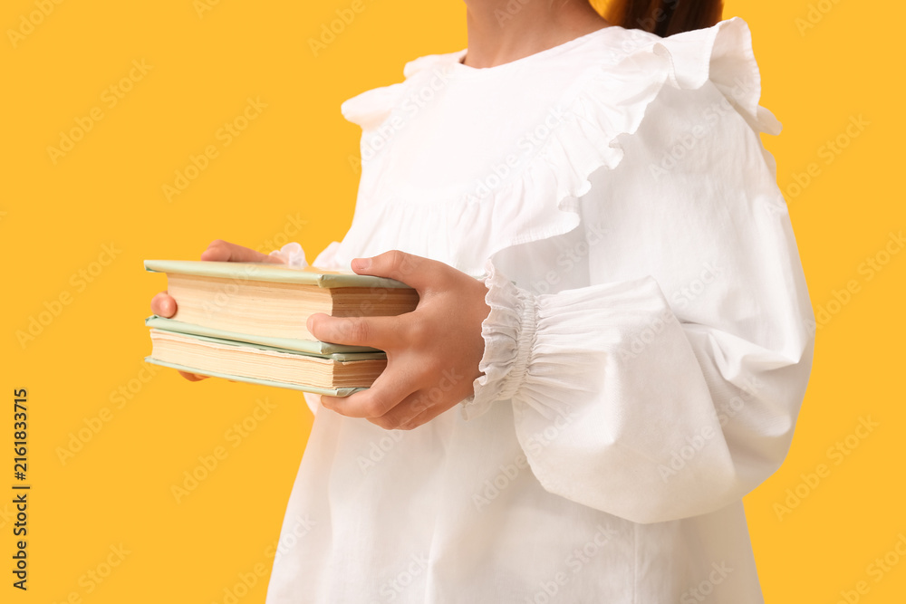 Naklejka premium Child with books on yellow background