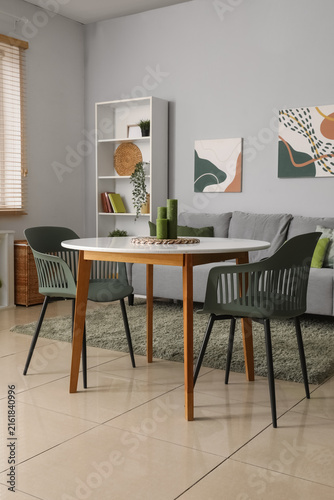 Stylish light living room with soft sofa, table and shelving unit