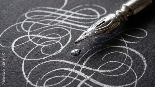 Vintage dip pen nib drawing white ink flourishes on black paper, macro calligraphy art