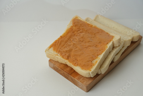 Obraz na plátně Sliced white bread rests on a wooden board