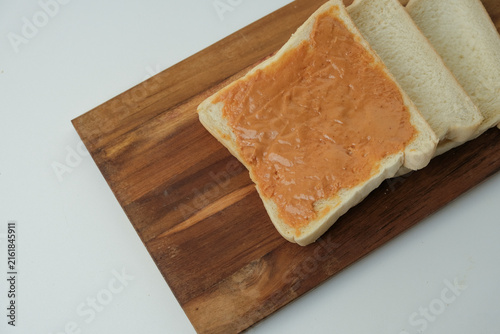 Фотография Sliced white bread rests on a wooden board