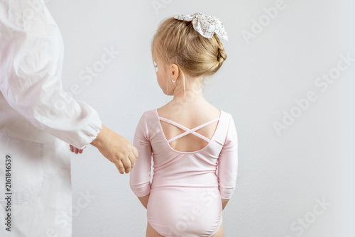 ballerina in Ballet leotard with female professional, medic or instructor, compassionate interaction between presumed doctor and young girl, receiving attention, dance injury