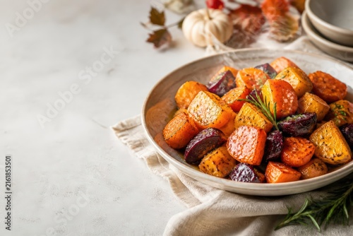 Roasted autumn root vegetables in ceramic bowl