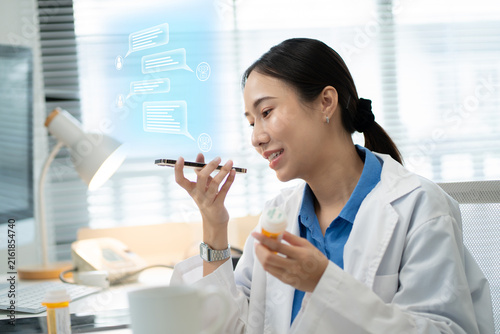 Quadro su tela Asian female doctor using a smartphone in a hospital,interacting with a virtual assistant or AI chatbot