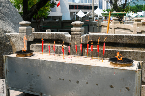 Fotografie Row of burning red chinese ritual candles at an outdoor incense altar area of th