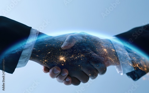 Two hands clasped in a firm handshake, overlaid with a glowing earth