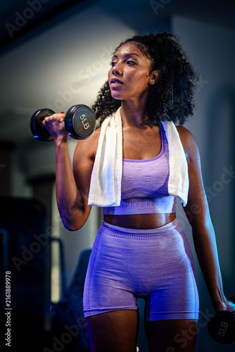Foto Women's strength and empowerment: an African American athlete raising a dumbbell