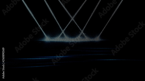 Spotlight beams hitting dark floor creating dramatic stage atmosphere with subtle blue light.