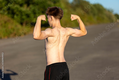 Shirtless Teenage boy flexing his back