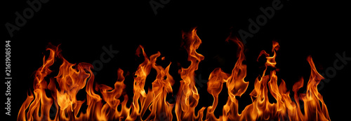 Fotografie Realistic orange fire flames rising across a black background, creating a powerful fiery border with glowing embers, dynamic movement, intense heat, dramatic contrast, and space for creative design