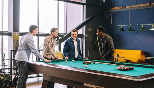 Group of Young Men Playing Billiards Together in a Stylish Lounge