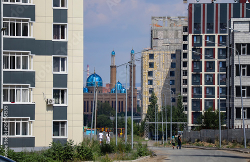 Perspective view of a new residential district featuring completed and under-construction apartment buildings, with a mosque visible in the distance. Ust-Kamenogorsk (kazakhstan)