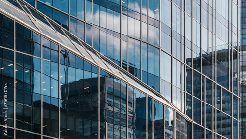 Modern glass office building facade with geometric architectural reflections