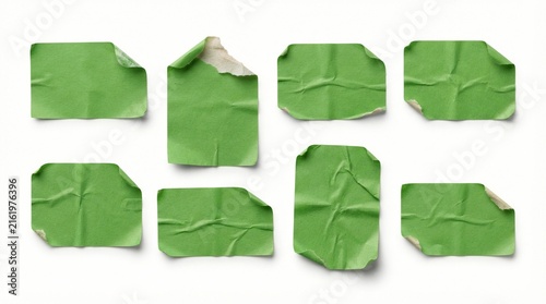 Green paper stickers featuring worn edges and wrinkled textures arranged in a scattered collection isolated on a plain white background for professional creative graphic design projects.