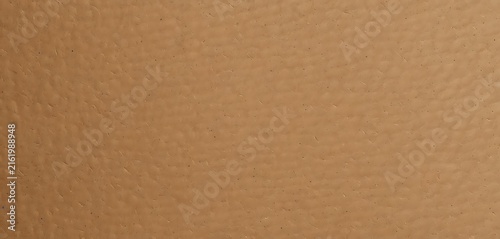 Close-up of textured brown paper surface with subtle grain and warm tone