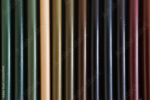 close-up of green and brown colored pencils neatly lined up in pencil case, concept of creativity, drawing, education and art supplies