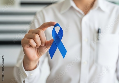 Person holding a blue awareness ribbon for prostate cancer, colon cancer, or mens health awareness