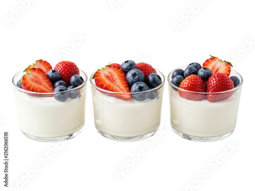 Three yogurt cups with fresh berries. Healthy dairy dessert with strawberries and blueberries.