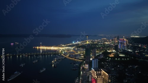 Drone video showing the illuminated Ha Long waterfront, harbor, skyline, bridges, and coastal attractions in Quang Ninh, Vietnam at night.