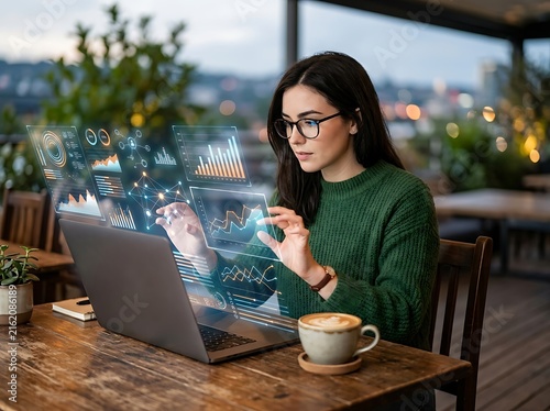 Woman using laptop with digital business charts in cafe