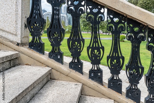 Fotografie Ornate black metal railing along stone staircase outdoors