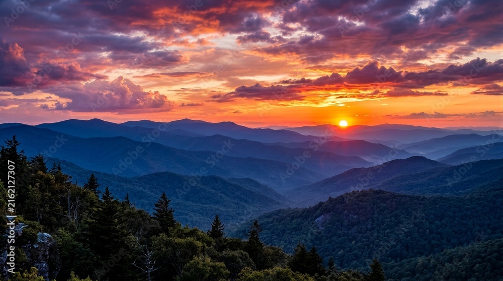 Fototapeta premium Mountain ridges glowing at sunset over layered valleys