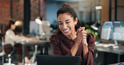 Happy, businesswoman and good news in office with laptop, email and notification of investment offer. Coworking, mature person smile or reading in workplace with computer, funding opportunity or deal