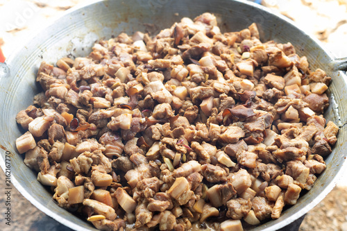 Several pieces of braised pork in a large pan.