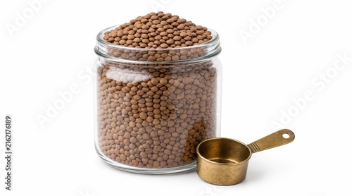 Jar of Dried Brown Lentils with Brass Scoop Isolated
