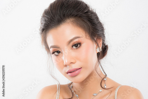 Focus on the delicate features of an elegant bride sparkling earring necklace and a gentle touch emphasizing her sophisticated allure studio shot on white background.