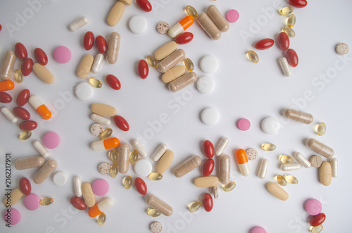 Multicolored vitamin capsules scattered on white background, representing vitamins dietary supplements, health care nutrition concept