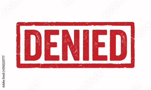 A red rectangular stamp displaying the word denied is isolated on a white background rejection refusal veto disapproval declination negation
