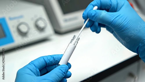 Close-Up View Of Gloved Hands Using A Cotton Swab For Medical Testing Preparations In A Laboratory Setting