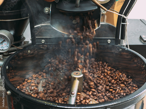 Obraz na plátně Roasted coffee beans dumped out of coffee roasting machine after it is done fini