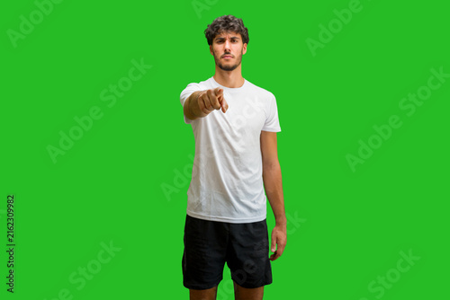 Foto Young man wearing t-shirt standing over isolated chroma background pointing disp