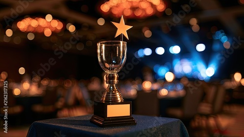 A golden trophy with a star on top sits on a blue cloth before a blurred banquet hall
