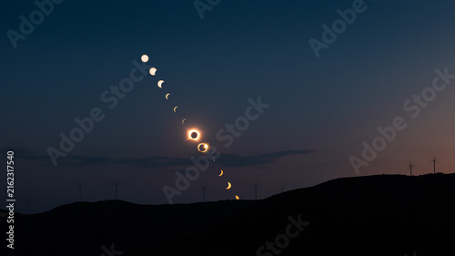 Fotografía Wide angle composite image of the phases of a total solar eclipse falling behind