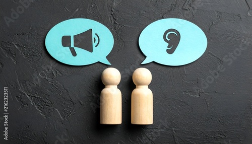 Two wooden figures beneath speech bubbles with megaphone and ear icons, symbolizing communication, announcements, listening, dialogue, and effective information sharing.