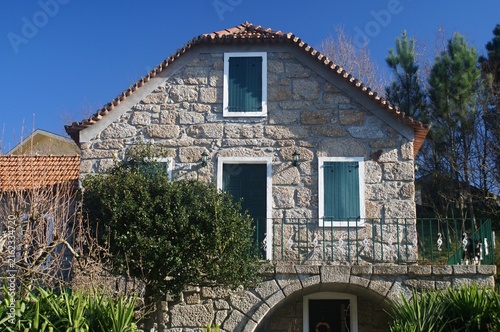 Traditional Portuguese stone house with green shutters. Portugal - Norte